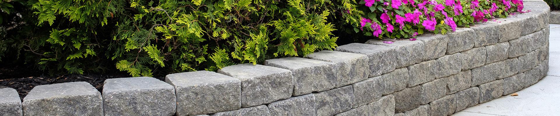 Stone retaining wall with shrubs and flowers